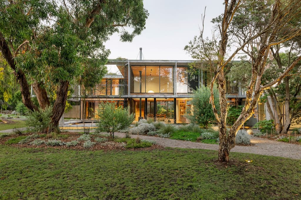 Hoisted among the treetops, an offbeat coastal hideaway opens to lush gardens